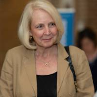 Woman in tan blazer listens